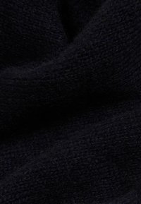 Black knitted fabric with a soft, textured appearance. Material shows a subtle mix of fibers with varying thickness in the weave.