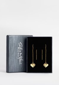 Goldene, herzförmige Ohrringe an Ketten, präsentiert in einer schwarzen Samtschachtel mit metallic grauer Außenseite. Enthält einen einfachen Ohrstecker im Stabdesign.