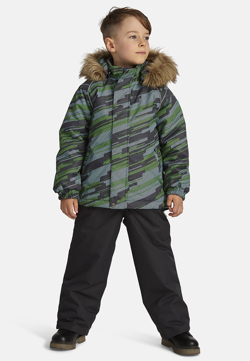 Zaļa un pelēka rakstainā pūkainā jaka ar kažokādas odere kapuci, apvienota ar melniem biksēm un izturīgām melnām zābakiem. Garas piedurknes ar elastīgām aprocēm.