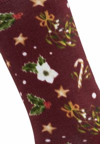 Calze bordeaux con un motivo festivo di foglie di agrifoglio, fiori bianchi, bastoncini di zucchero, stelle dorate e dettagli in verde e rosso.