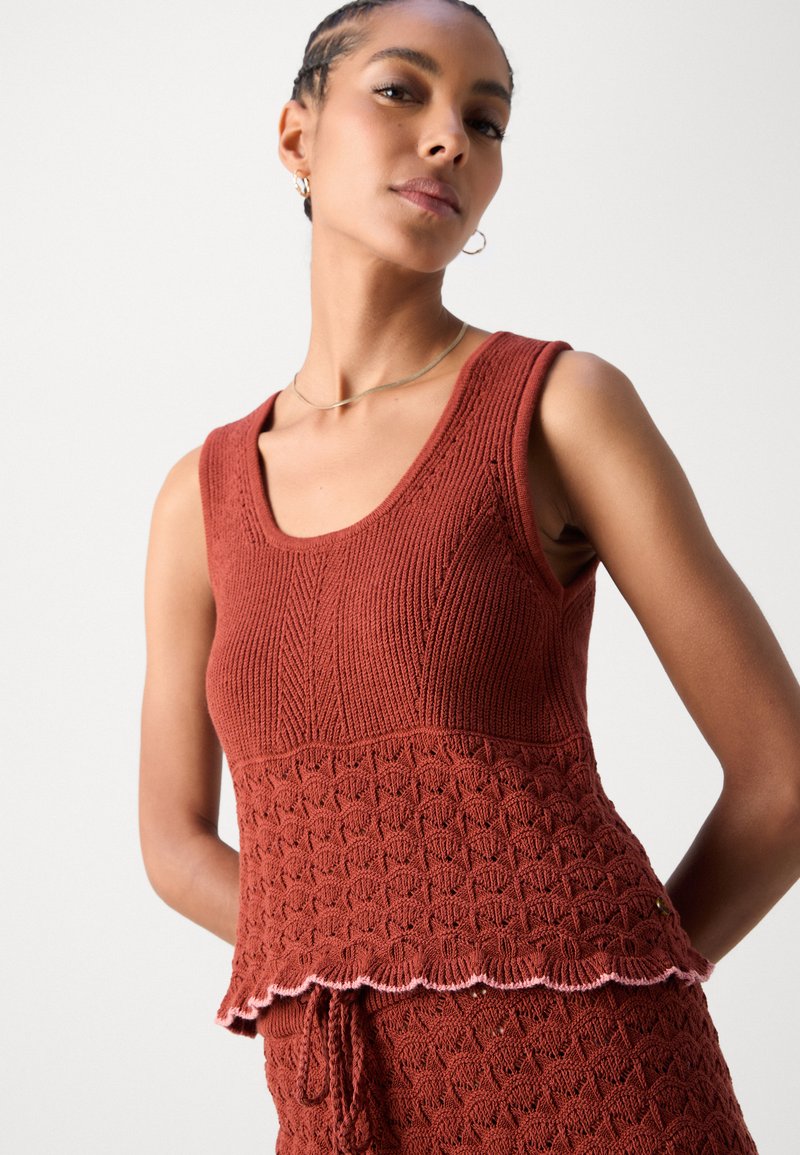 Rostfarbener, gestrickter Tanktop mit strukturierten Mustern, gewelltem Saum und taillierter Silhouette. Verfügt über breite Träger und ausreichend Stretch.