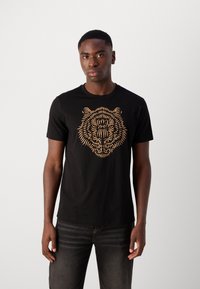 Black cotton t-shirt featuring an orange tiger head graphic, round neckline, and short sleeves, with a smooth texture and fitted design.
