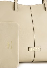 Beige læder tote bag med struktureret form, der har et guld logo og en matchende lille pung. Tekstureret overflade og kraftige håndtag.