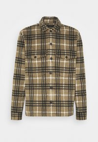 Bruin en zwart geruit flanellen shirt met knoopsluiting, twee voorzakken en een klassieke kraag. Zachte textuur, casual ontwerp.
