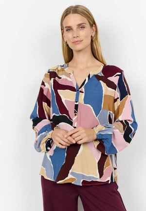 Blouse multicolore à boutons dans un tissu doux. Présente des motifs abstraits en rose, bleu, beige et bordeaux. Manches longues avec des poignets élastiques.