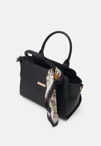 Czarna skórzana torebka z dwoma uchwytami, przednią kieszenią oraz ozdobną apaszką w kwiatowy wzór przywiązaną do jednego uchwytu. Akcenty ze złotego metalu.
