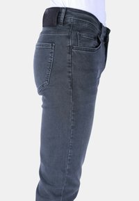 Slim-fit grijze denim jeans met een klassiek vijf-pocket ontwerp, zichtbare naden en een leren patch op de tailleband.