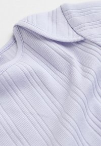 Hele lilla soonikud helesinine ülaosa ümara kaelusega ja pehme tekstuuriga, millel on õrnad vertikaalsed triibud ja siledad servad.