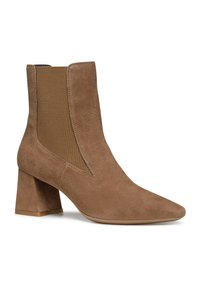 Stivale alla caviglia in suede marrone con punta appuntita, pannelli laterali elastici e tacco spesso. Texture liscia e design minimalista.
