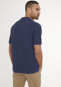 Námornícky polo shirt s krátkým rukávem a texturovaným vzorem, s plochým límcem a žebrovanými manžetami, doplněný o khaki kalhoty.