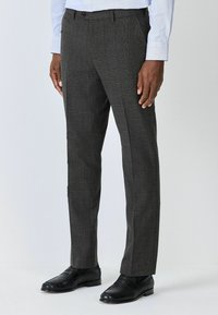 Maßgeschneiderte graue Hosen mit einem subtilen Karomuster, hergestellt aus einem strukturierten Stoff, mit einem Knopfverschluss und einer eleganten Bügelfalte vorne.