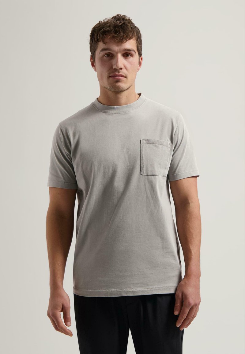 Light grey cotton t-shirt with short sleeves, round neckline, and a chest pocket. Regular fit with visible stitching details.