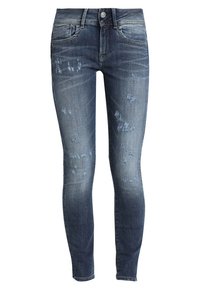 Jeans ajustados en denim de lavado oscuro con un aspecto deslavado, que presentan un ligero desgaste y un cierre de botón en la cintura.