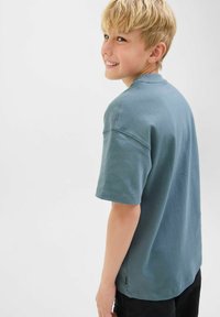 T-shirt azzurro chiaro a maniche corte realizzato in cotone morbido, con una vestibilità comoda e dettagli di cucitura visibili. La maglietta ha un orlo dritto.