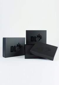 Black rectangular boxes with a glossy finish, featuring a raised logo "DL" and a graphic of a horse's head. One box is partially open.
