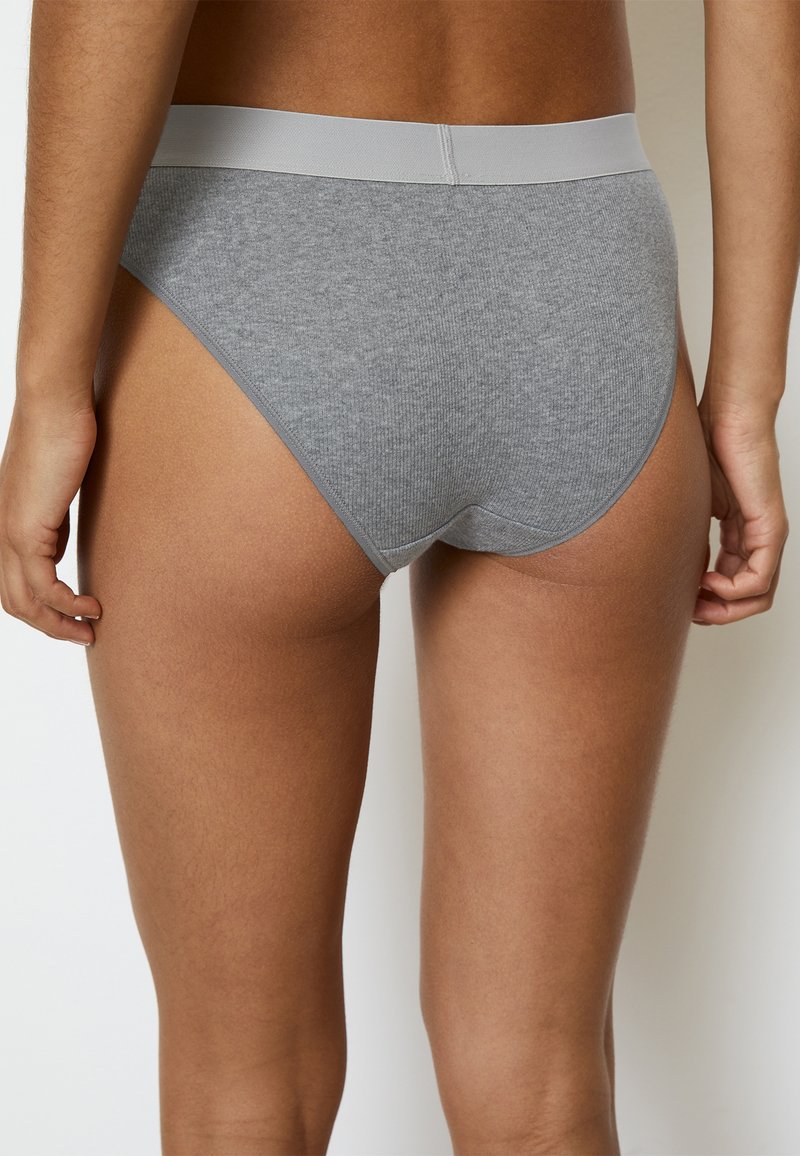Slip in cotone grigio con una cintura elastica liscia, caratterizzato da un design semplice e una vestibilità aderente. Il tessuto ha un aspetto morbido e texturizzato.