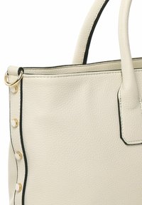 Sac fourre-tout en cuir crème clair avec quincaillerie dorée, accents noirs et surface texturée. Comprend des poignées arrondies et des clous décoratifs.
