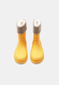 Botas de goma amarillas con un puño de forro polar gris y un suave forro interior, que presentan un diseño sencillo y redondeado, además de una suela texturizada para un mejor agarre.
