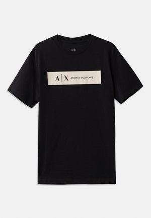 T-shirt nera a maniche corte con scollo rotondo, dotata di un'etichetta rettangolare beige con la scritta "A|X Armani Exchange" sopra il petto.