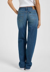 Vaqueros de denim azul con un diseño de pierna recta, que presentan una etiqueta de cuero de Lee en la cinturilla y un sutil bordado en los bolsillos traseros.