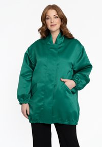 Groene satin jas met een hoge kraag, elastische manchetten en zijzakken. Het ontwerp heeft een licht oversized pasvorm en een gladde textuur.