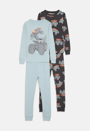 Zweiteiliges Kinderpyjama mit einem hellblauen Oberteil, das ein Monstertruck-Motiv zeigt, und einer schwarzen Hose mit einem durchgehenden Monstertruck-Design.