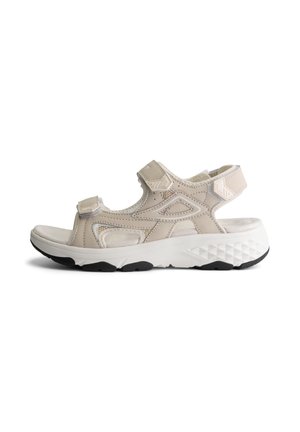 Beige sportsandaal met open teen en verstelbare bandjes, voorzien van een gevoerde binnenzool en een dikke witte zool met zwart loopvlak voor gebruik buitenshuis.