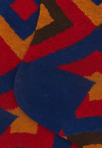 Calze colorate con motivi a disegno che presentano forme geometriche interconnesse in rosso, blu, giallo e marrone; realizzate in morbido materiale a maglia con polsini a coste.