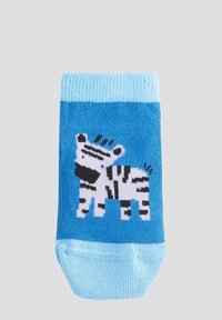 Calze blu con motivo a zebra in bianco e nero. Il materiale sembra morbido con una texture a coste e un risvolto di un blu chiaro a contrasto.