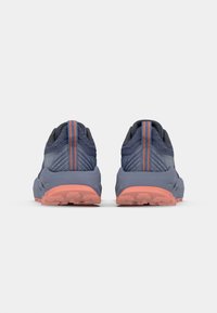 Blauwe sport schoenen met een gestructureerd mesh bovenwerk, oranje accentstrepen en een duurzame rubberen tussenzool. De achteraanzicht toont het schokabsorberende ontwerp.