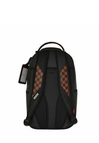 Mochila negra con respaldo y correas acolchadas, que presenta un acento de patrón a cuadros marrón, materiales texturizados y una etiqueta de marca en el lateral.