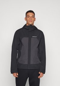 Black waterproof jacket with a grey panel, zippered pockets, and a hood, featuring a logo on the upper left. Smooth, lightweight fabric.