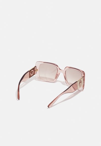 Óculos de sol rosa transparentes com armações quadradas, lentes com tonalidade e detalhes em dourado nas hastes. Material plástico leve.