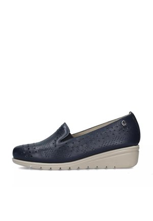 Scarpa slip-on in pelle traforata blu navy con suola beige a zeppa e piccolo logo metallico vicino al tallone, progettata per il comfort e l'uso casual.