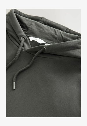 Tmavohnedá mikina vyrobená z mäkkej tkaniny, ktorá má predné klokanie vrecko, kapucňu so sťahovacou šnúrkou a štítok vo vnútri. Jednoduchý dizajn a textúra.