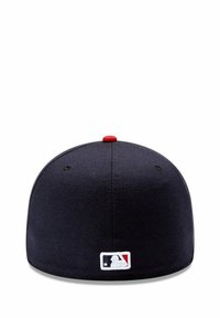 Gorra negra ajustada con corona redondeada, botón rojo en la parte superior y logotipo de MLB bordado en blanco en la parte trasera. Textura de tela suave.