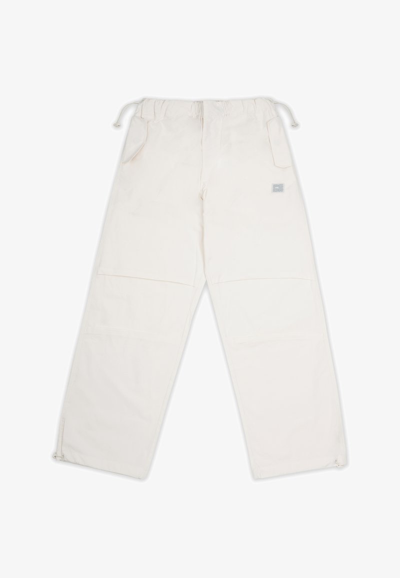 Pantalons blancs avec une taille élastique, deux poches latérales et des bas zippés. Fabriqués dans un tissu à texture lisse et à la décoration minimale.