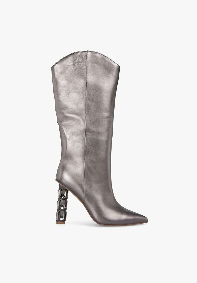 Botte argentée métallisée montante avec un bout pointu et un talon géométrique épais comportant des accents noirs. Texture lisse et design épuré.