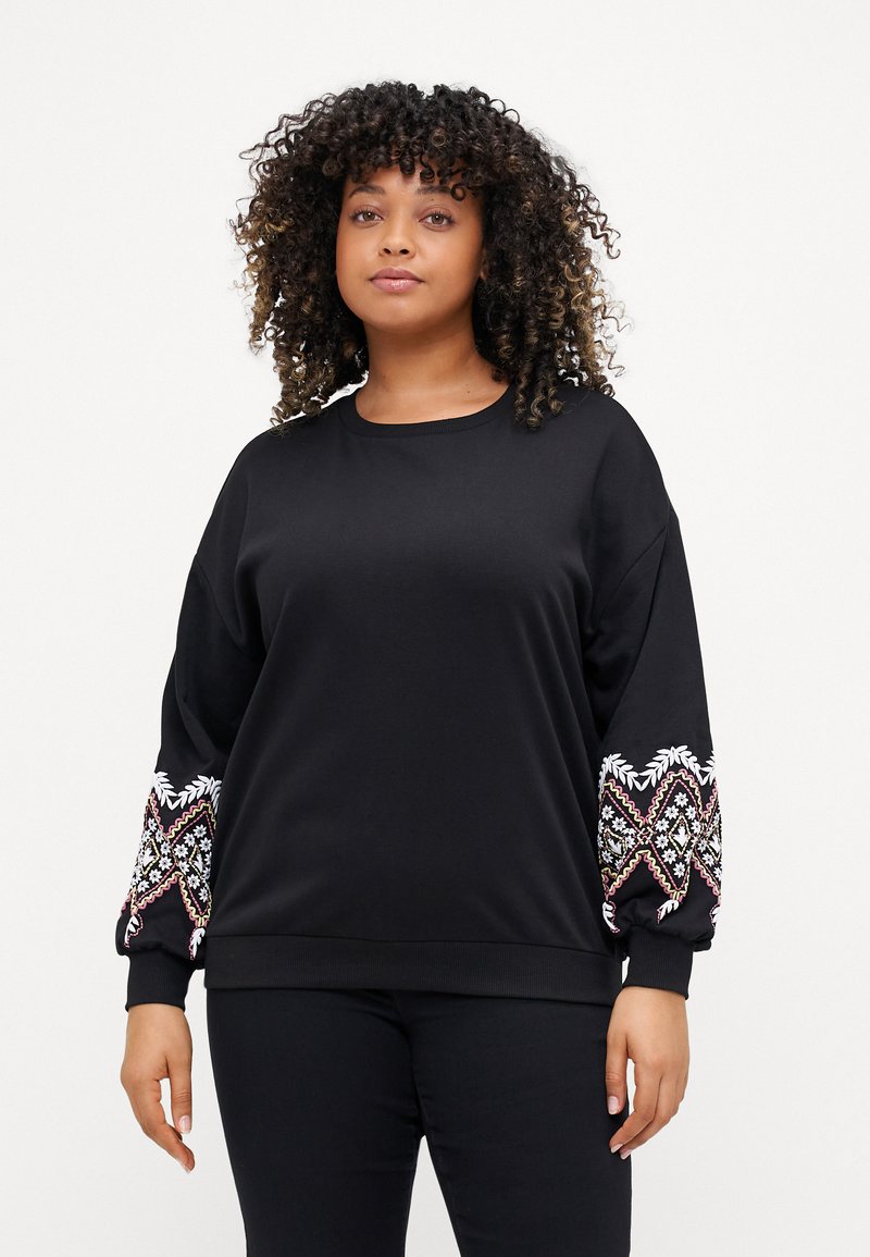 Svart sweatshirt med långa, puffiga ärmar som har flerfärgad, intrikat broderi längs manschetterna, rund halsringning och mjuk textur.