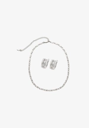 Srebrny naszyjnik z ogniwami łańcuszka i zapięciem, zestawiony z srebrnymi kolczykami w kształcie kół z trzema przejrzystymi kamieniami na każdym.