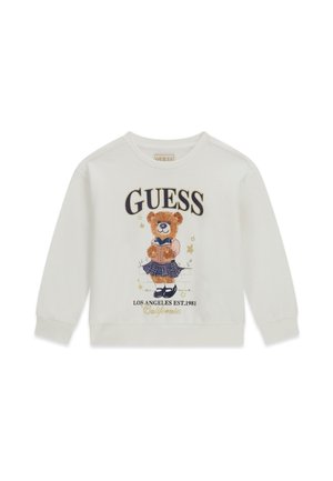 Witte trui met lange mouwen met een beer die een geruite rok draagt en een boek leest, en de tekst "GUESS Los Angeles Est. 1981 California."