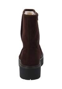 Stivaletto in suede marrone con una morbida fodera, chiusura con zip e una spessa suola in gomma nera. Presenta una punta arrotondata e una finitura liscia.