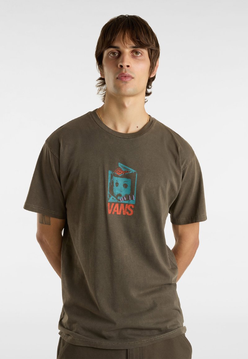 Olivově zelené bavlněné tričko s kulatým výstřihem, na kterém je barevný grafický potisk obličeje a text "VANS" uprostřed. Krátké rukávy.