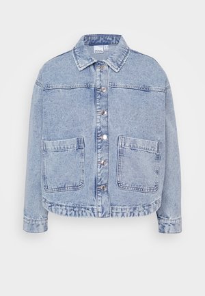 Jaqueta de ganga azul clara com fecho frontal de botões, dois grandes bolsos frontais e colarinho. Apresenta uma barra ligeiramente encurtada e um ajuste descontraído.