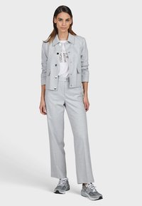 Light gray tailored jacket with matching pants, featuring a white t-shirt with sequin detail, and gray athletic shoes. Smooth texture and modern fit.