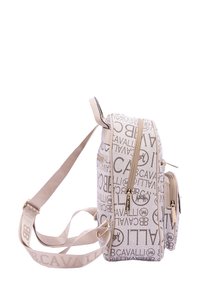 Sac à dos beige avec tissu texturé, arborant un logo de marque répété. Deux compartiments zippés et une bandoulière ajustable.