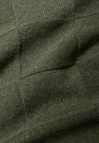 Tessuto lavorato a maglia verde scuro con un motivo a quadri testurizzato. Il materiale sembra morbido e caldo, evidenziando bordi a coste e una finitura pelosa.