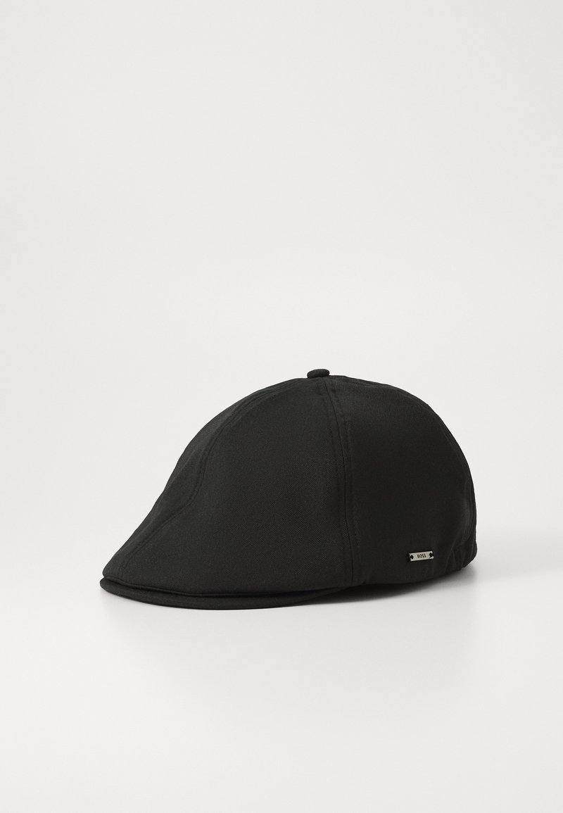 Black cap with a curved peak, crafted from smooth fabric, featuring subtle stitching details and a small metal logo tag on the side.