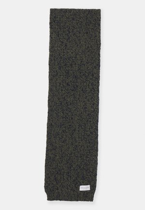 Knit scarf in dark green with a textured pattern. Features a small tag at the bottom edge, rectangular shape, and soft material.