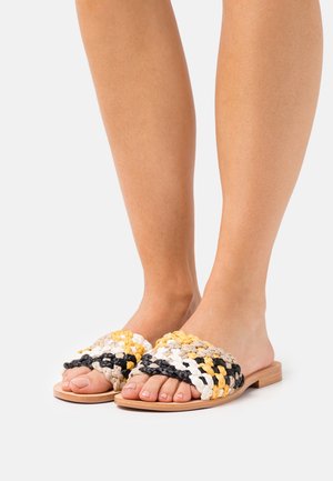 Sandalias tipo chancla tejidas con una mezcla de hilos en amarillo, negro, gris y blanco. Diseño de punta abierta con suela de madera natural.